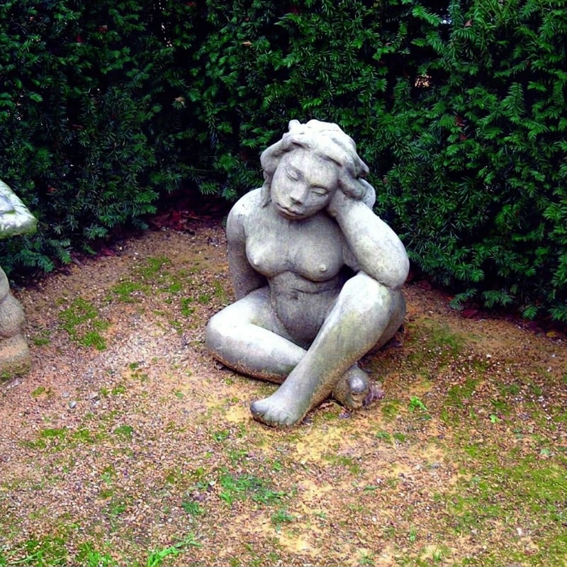 Seated Gaia mythological garden statue UK Greek earth mother in Cotswold stone for a wildlife garden