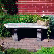 Curved Pattern Stone Garden Bench in natural garden setting with brick paving