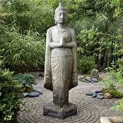 Standing Buddha Statue in a zen garden setting with bamboo and gravel