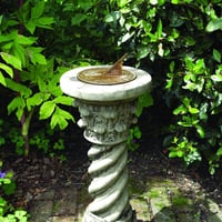 Aged brass sundial on Roman stone pedestal