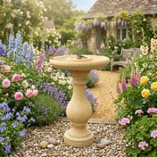 Fosse Birdbath in Sandstone in a cottage garden setting