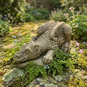 Dragon Hatchling Stone Garden Ornament in a cottage garden setting with moss and ferns