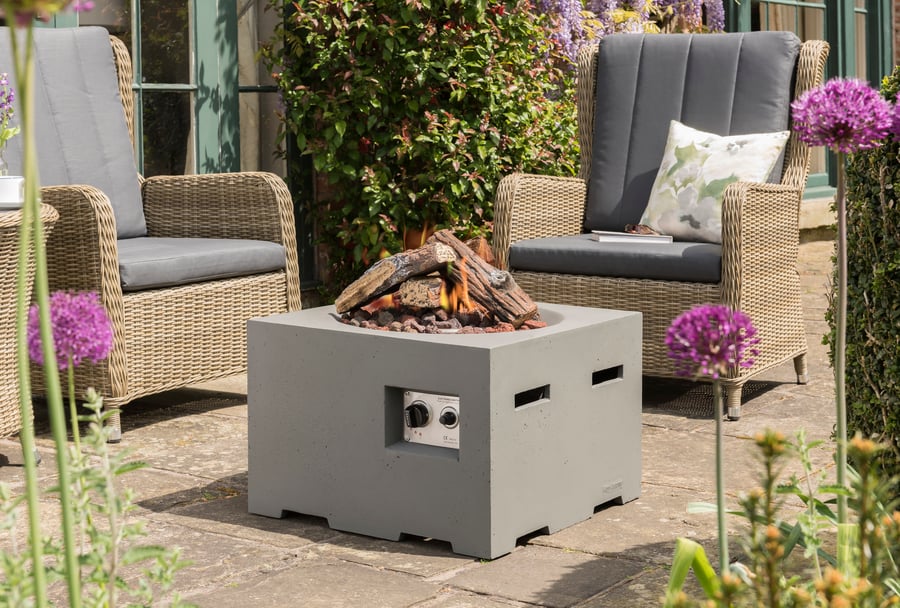 Happy Cocoon 60cm small square grey wood-burning fire pit in a contemporary UK courtyard at dusk