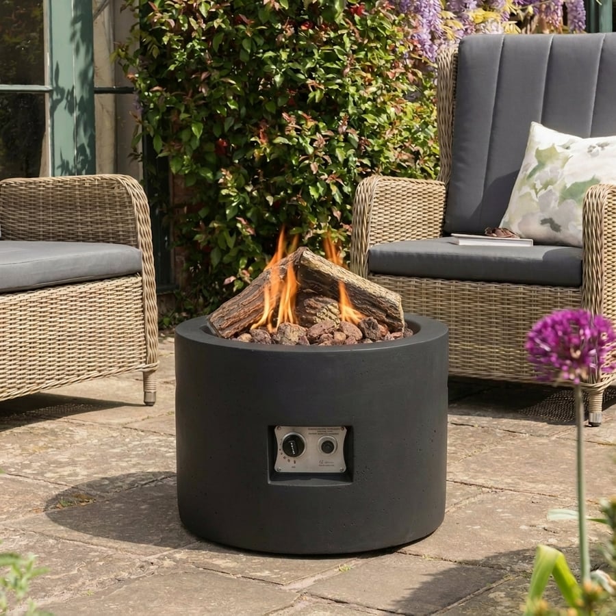 Happy Cocoon 61cm round wood-burning fire pit in a UK garden showing legal Ready to Burn logs setup
