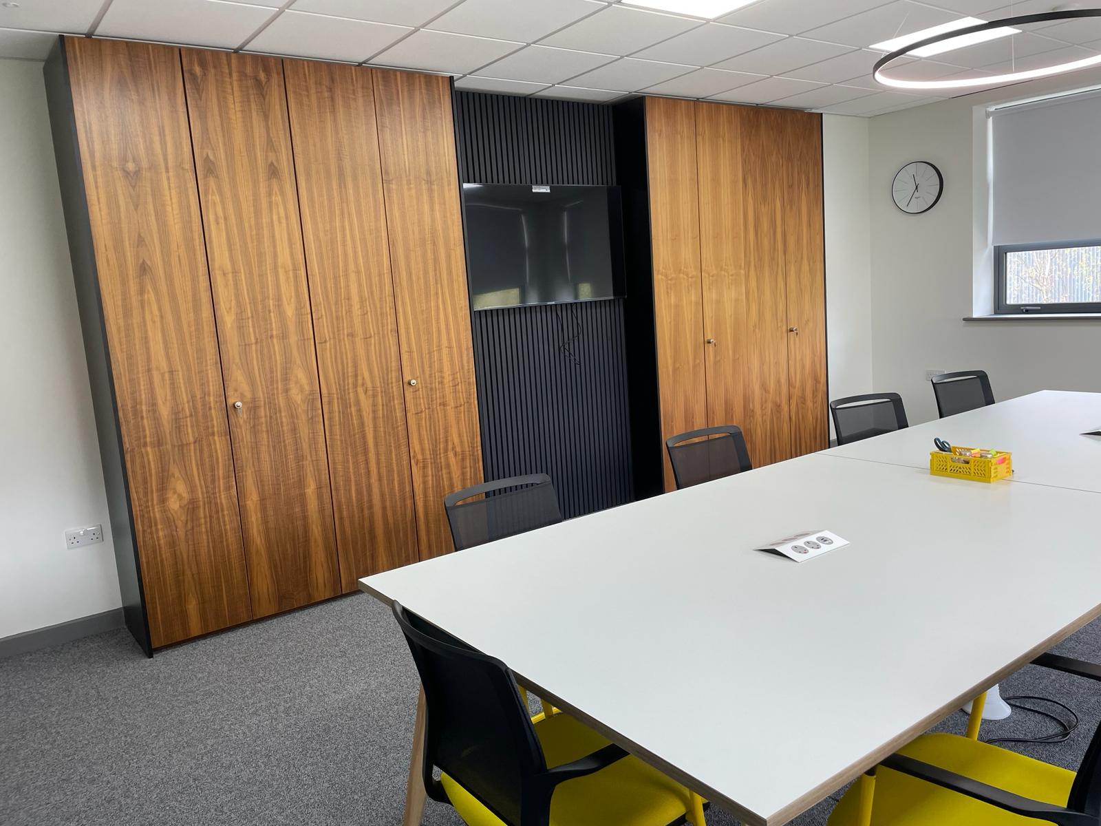 Card factory wakefield meeting room with relocated storage wall, wall mounted screen and black slatted feature panel