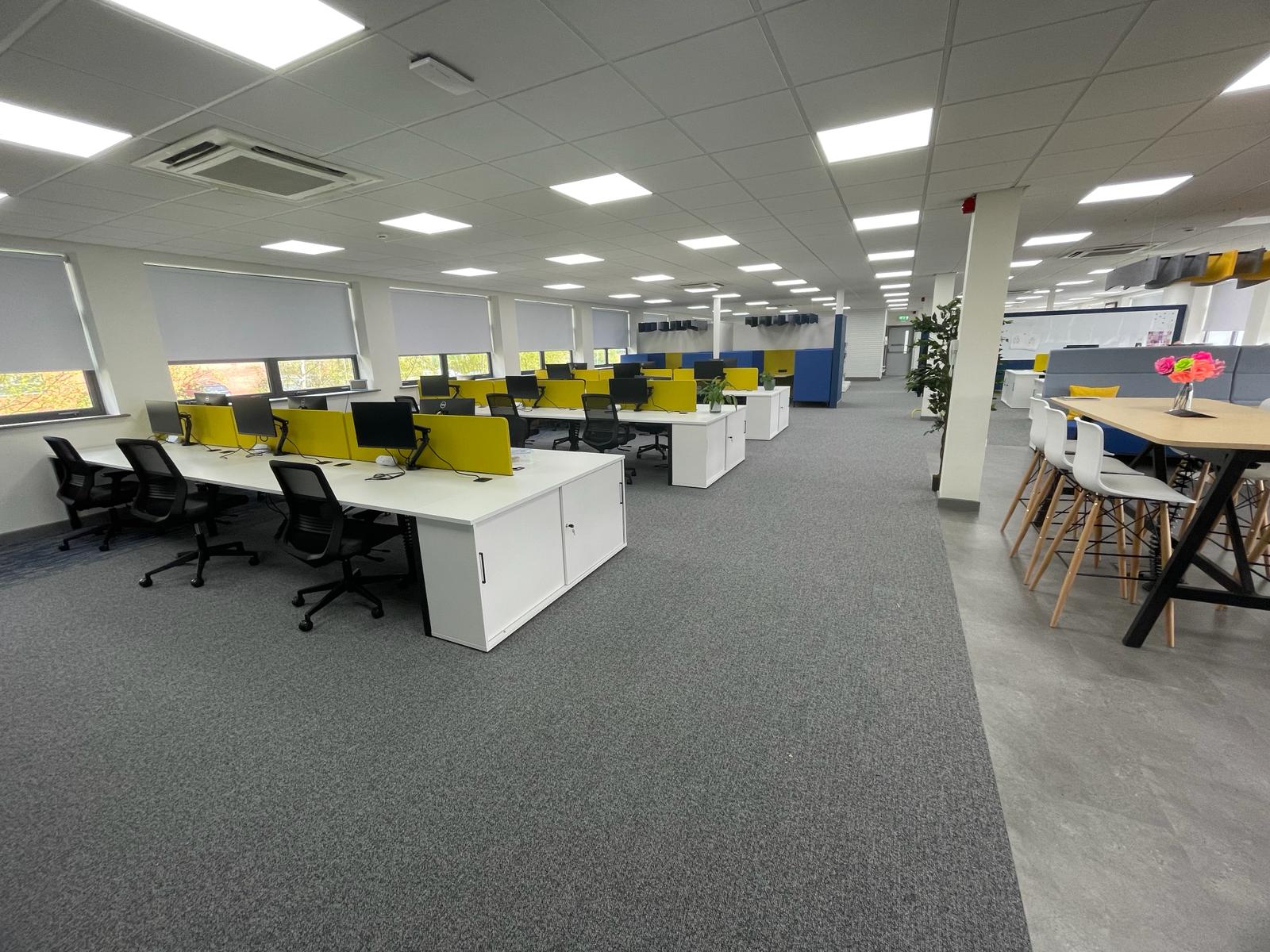 Open plan workspace completed as part of the card factory wakefield office refurbishment, with white desks, yellow desk screens and breakout seating