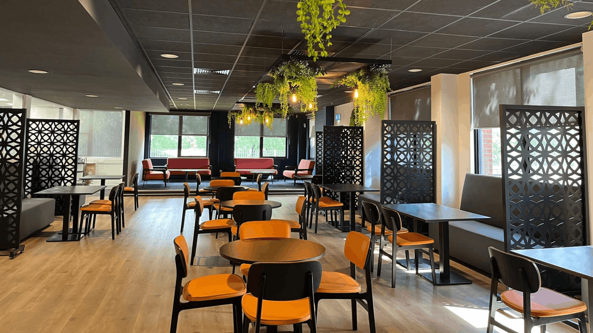 Riviera travel breakout area with booth seating, decorative privacy screens and lounge seating zone