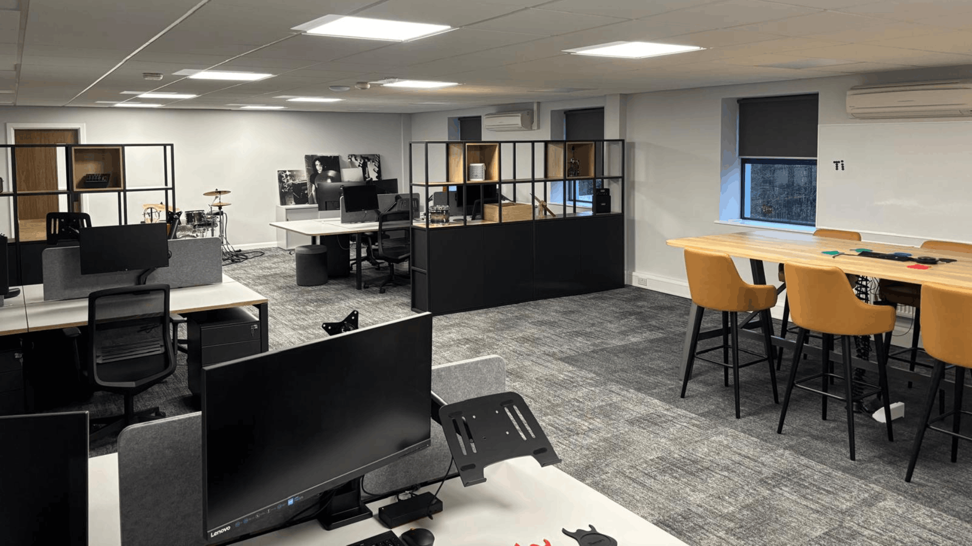 Headstock group open-plan workspace with desk areas, cubeform feature dividers, display shelves and pallet wood feature wall