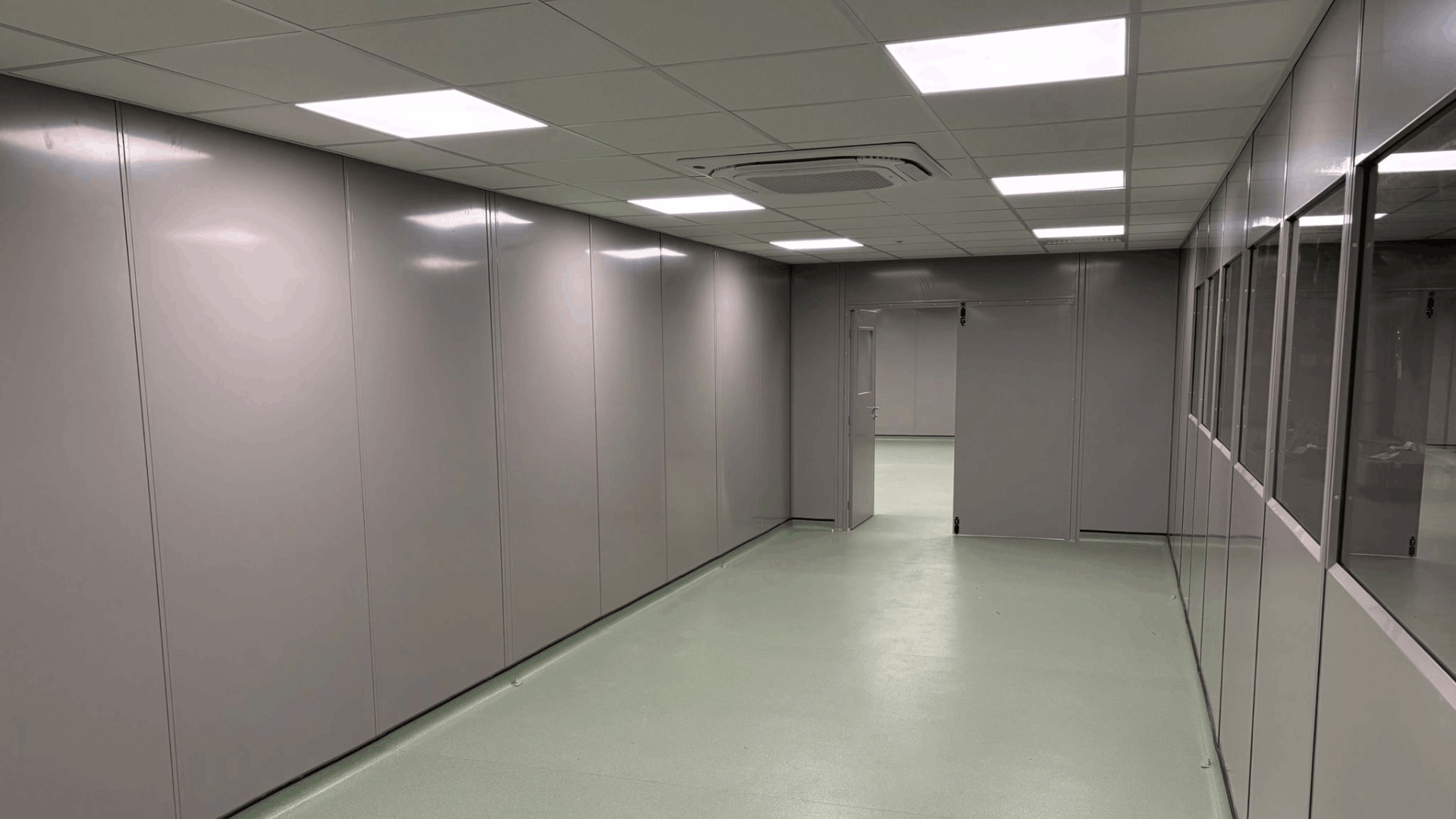 Internal clean room access corridor with steel partition walls, glazed panels, led lighting and cap and cove safety flooring.