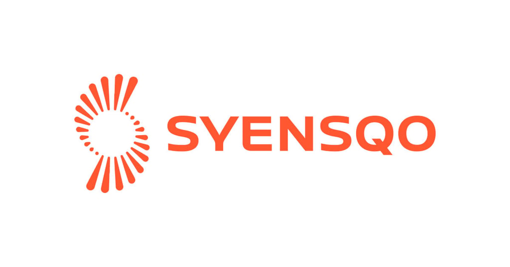The syensqo logo displayed on a clean white background, featuring an orange abstract circular emblem made up of curved lines, dots, and elongated shapes to the left, followed by the word “syensqo” in bold uppercase orange lettering.