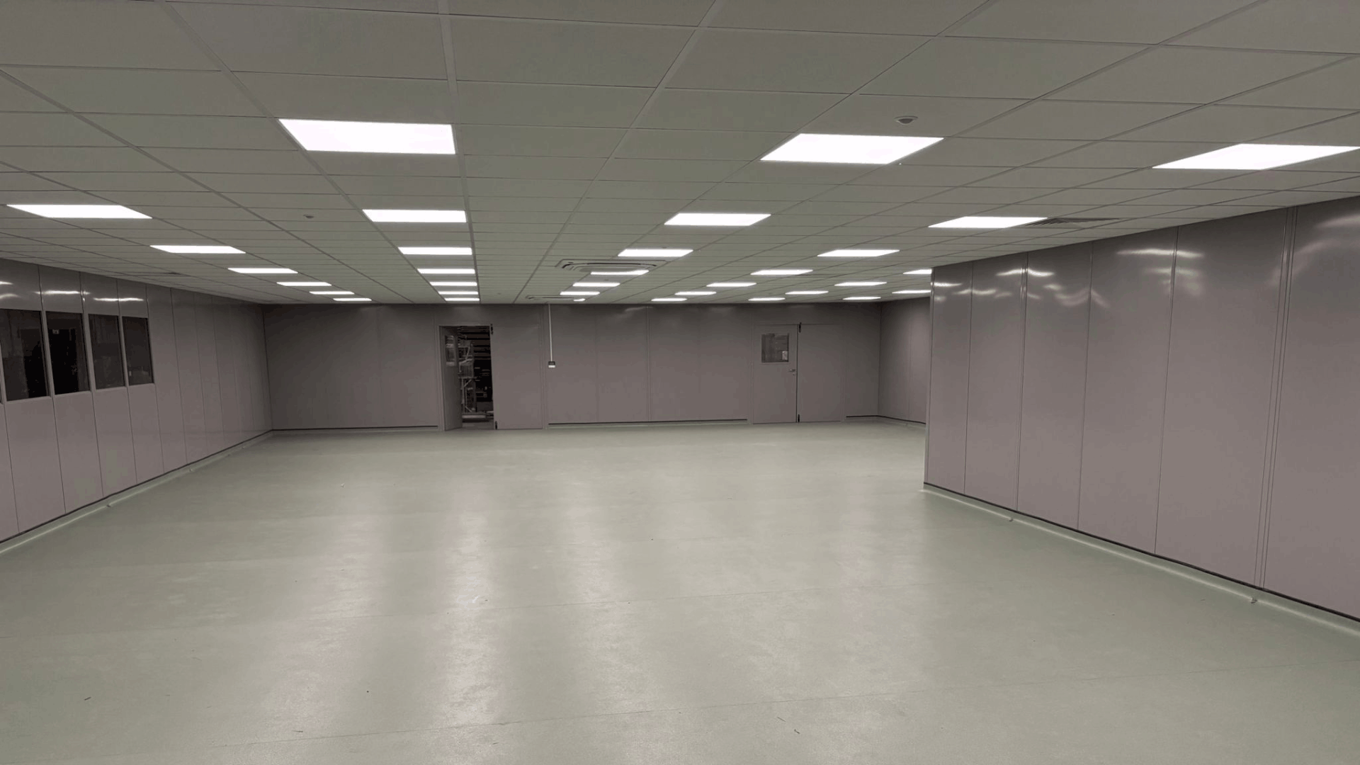 Wide view of the completed molymer moulding services clean room with steel partitioning, access doors, lighting and safety vinyl flooring.