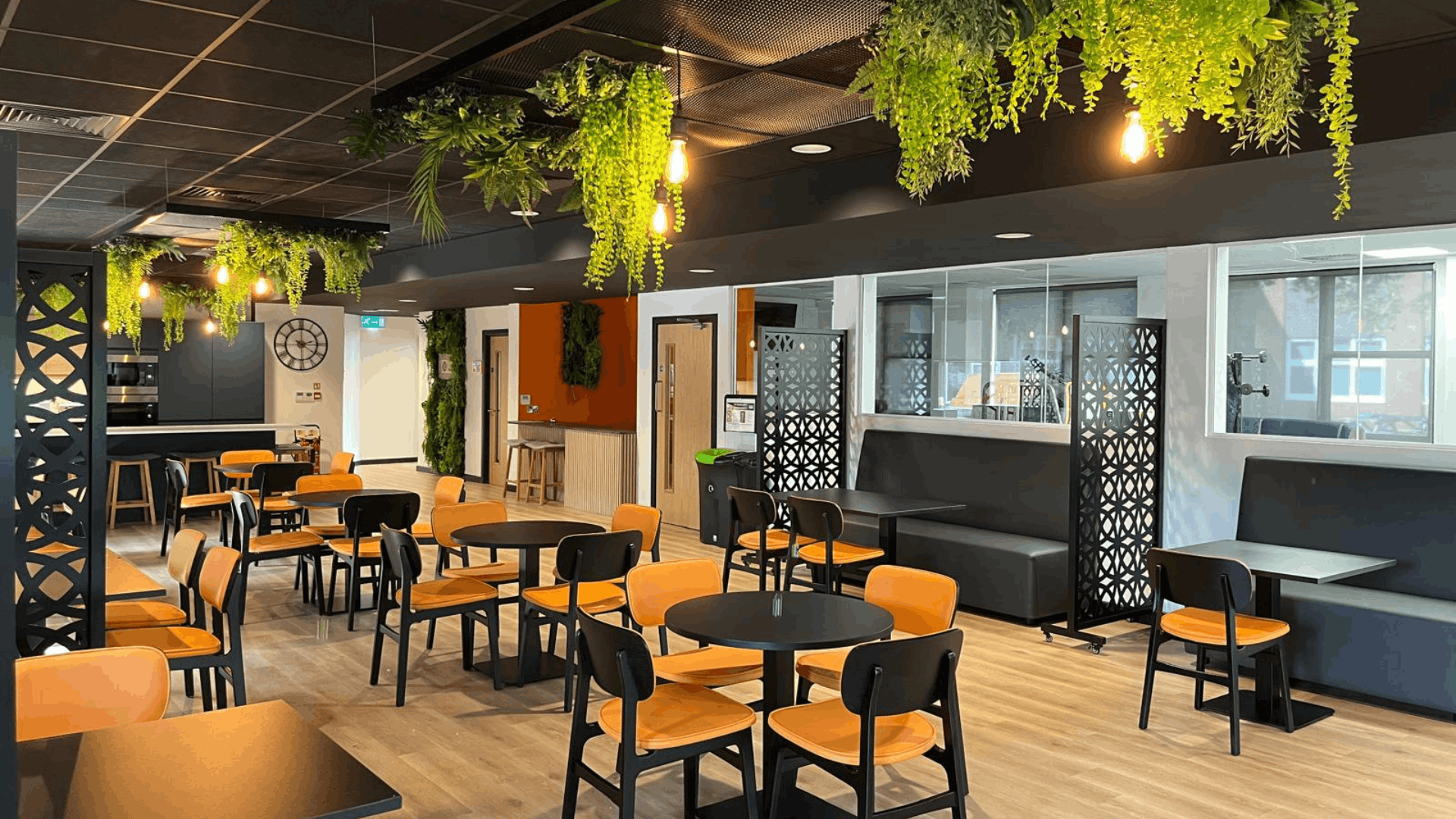 Open-plan riviera travel breakout space with decorative screens, feature planting and office glazing