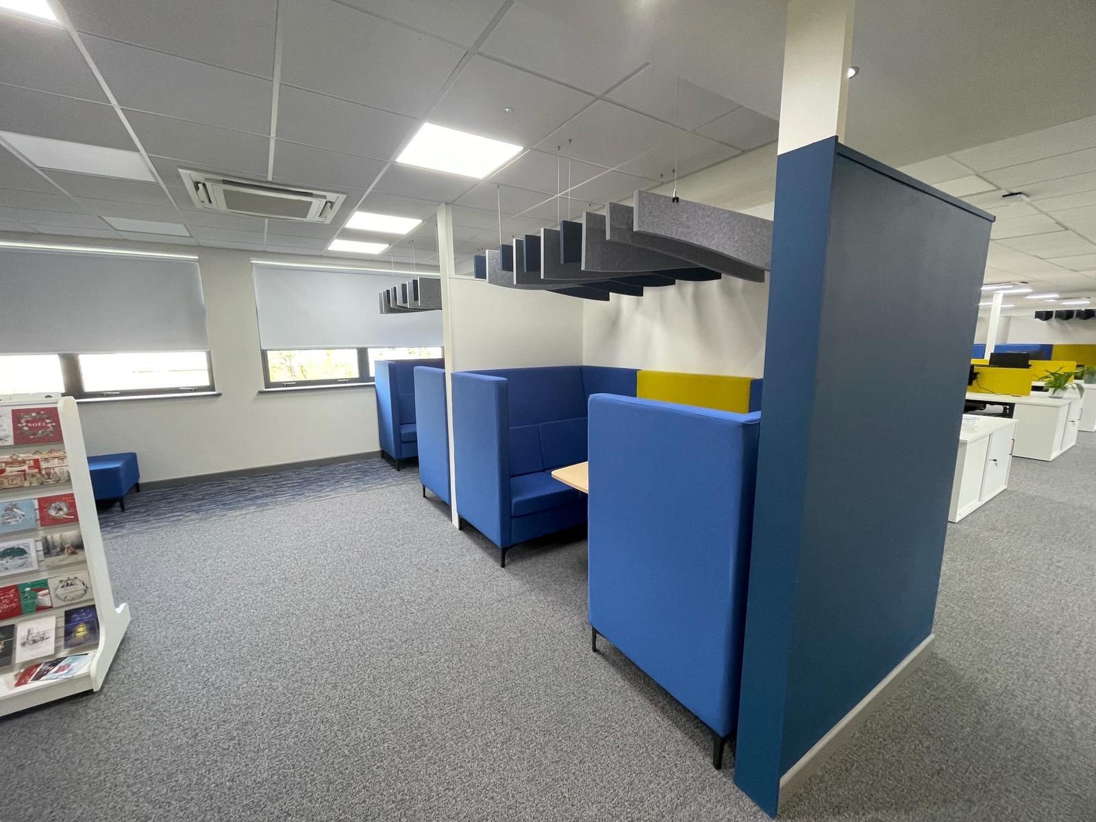 Acoustic meeting booths within the card factory wakefield office refurbishment, featuring blue seating and suspended acoustic ceiling baffles
