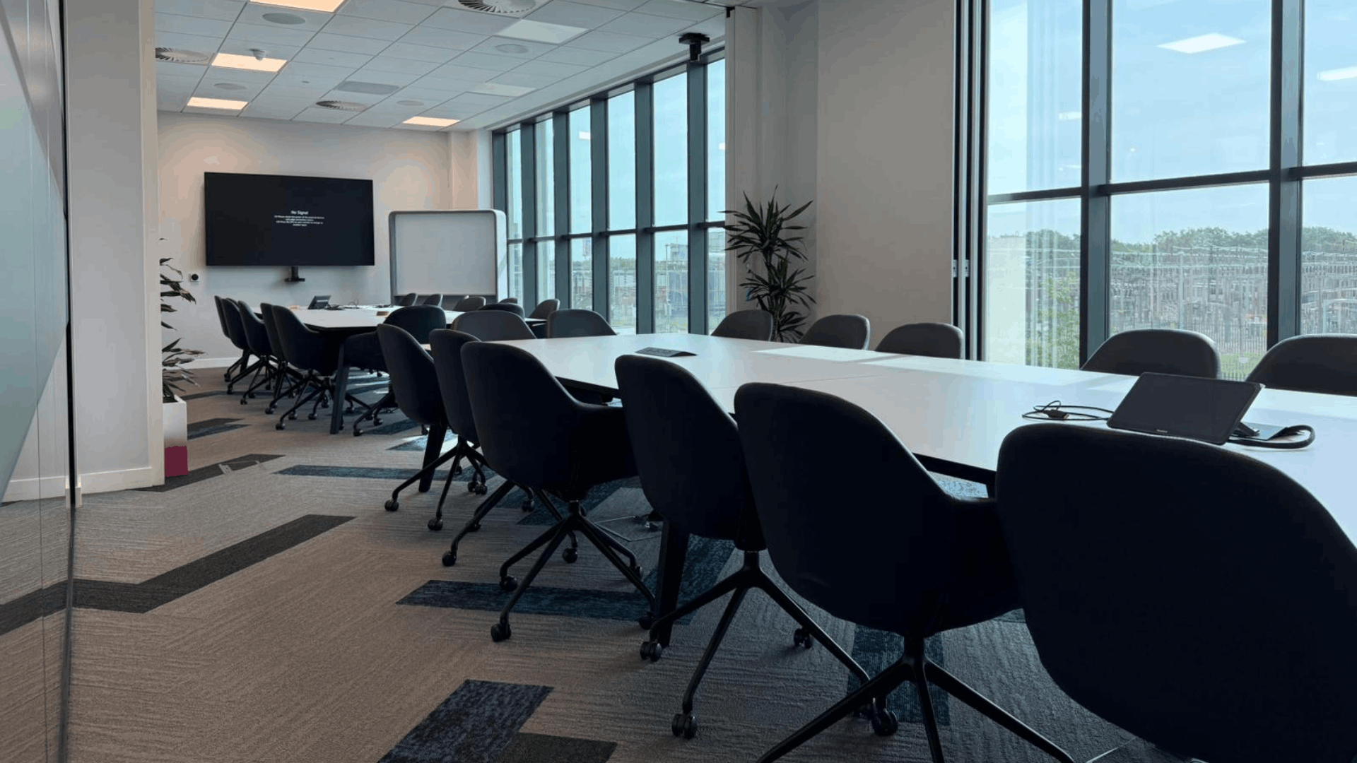 Completed smurfit westrock meeting room with glass partitions, walnut doors and patterned carpet tiles