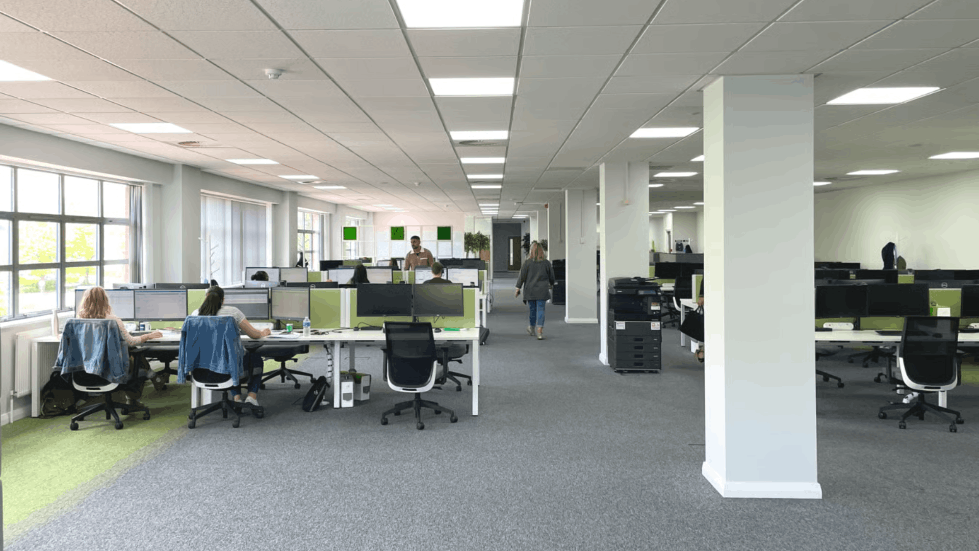 Open-plan office refurbishment with modern desks, ergonomic seating, green design features, and bright workspace