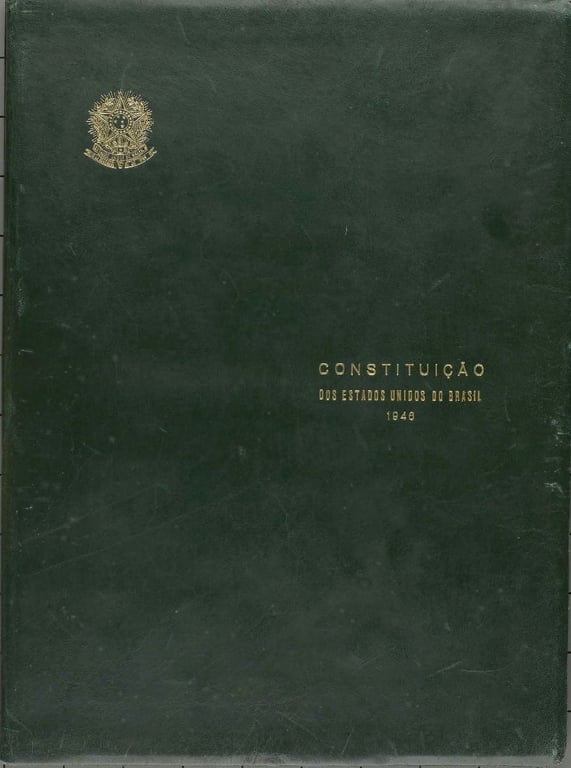 Capa da Constituição dos Estados Unidos do Brasil de 1946, encadernada em couro verde-escuro com letras douradas centralizadas e o brasão da República no alto.