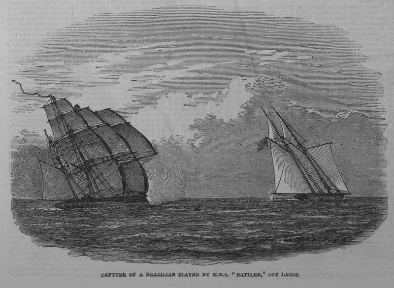 A ilustração em preto e branco retrata a captura de um navio negreiro com comandante brasileiro em Lagos, atual Nigéria, em 1849. À esquerda, o navio H.M.S. 'Rattler' é mostrado navegando com suas velas cheias pelo vento, enquanto à direita, o navio negreiro 'Andorinha', com velas menores, tenta escapar. O 'Rattler' está em posição de perseguição, representando a supremacia naval e o esforço de combate ao tráfico de escravizados pela marinha britânica. As águas estão calmas sob um céu nublado, refletindo a tensão do momento. A imagem histórica foi reproduzida da Manuscript, Archives and Rare Book Library, Emory University, e documenta a interceptação de um navio frequentemente usado no tráfico de escravizados na região do Golfo do Benim, destacando o papel da marinha britânica na repressão ao tráfico transatlântico de escravizados.