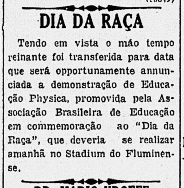 Recorte de jornal em preto e branco com o título em destaque 'DIA DA RAÇA', em letras maiúsculas e negrito. O texto informa que, devido ao mau tempo, foi adiada uma demonstração de Educação Física promovida pela Associação Brasileira de Educação em comemoração ao 'Dia da Raça'. O evento seria realizado no estádio do Fluminense, mas nova data seria anunciada posteriormente. Essa nota, publicada no mesmo jornal que exaltava o 'Descobrimento da América', ilustra como o Estado Novo, sob Getúlio Vargas, instrumentalizou datas comemorativas para promover uma ideia de identidade nacional baseada em ideais de unidade racial e moral. O 'Dia da Raça' fazia parte de um projeto que afirmava a existência de uma 'democracia racial' no Brasil, apagando conflitos e desigualdades entre brancos, negros e indígenas e promovendo o branqueamento simbólico e populacional do país. Esses eventos cívico-educativos, promovidos por instituições como a Associação Brasileira de Educação, eram ações concretas do regime para inculcar tais valores, alinhando educação física, civismo e nacionalismo a uma narrativa racializada e homogênea da identidade brasileira.