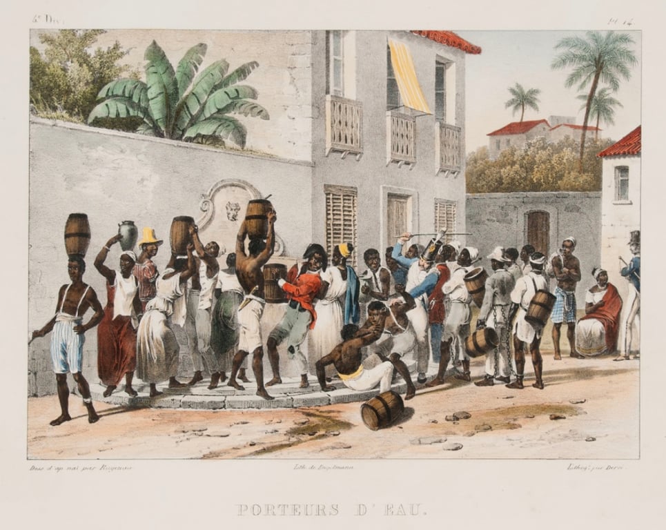 Ilustração “Ganhadores”, de Johann Moritz Rugendas, disponível no acervo Slavery Images. A cena retrata o cotidiano de africanos escravizados em um chafariz no Brasil da década de 1830. Em primeiro plano, homens e mulheres negros carregam grandes potes, barris e tonéis sobre a cabeça, nos ombros e presos ao corpo, enquanto coletam e transportam água. No centro da composição, um grupo de pessoas se aglomera durante uma briga entre escravizados, enquanto um agente da Guarda Imperial intervém na confusão com um bastão erguido. À esquerda e à direita, outros trabalhadores seguem com recipientes cheios, aguardam sua vez no chafariz ou conversam. Ao fundo, aparecem construções coloniais com janelas e sacadas, muros altos, árvores e algumas pessoas observando a movimentação. A gravura registra o trabalho dos ganhadores e a intensa circulação de pessoas em um espaço urbano do Brasil no século XIX.