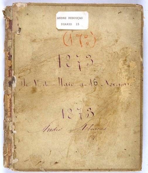 Capa envelhecida do diário de André Rebouças, referente ao ano de 1873, pertencente ao acervo da Fundação Joaquim Nabuco. A capa apresenta marcas do tempo, com manchas, desgastes e partes descascadas. O título e a data '1873' estão escritos em tinta roxa, com a inscrição do nome 'André Rebouças' ao final da página. O diário documenta as reflexões e registros do engenheiro e abolicionista André Rebouças, que teve papel fundamental na luta pelo fim da escravidão no Brasil e na modernização das infraestruturas do país.