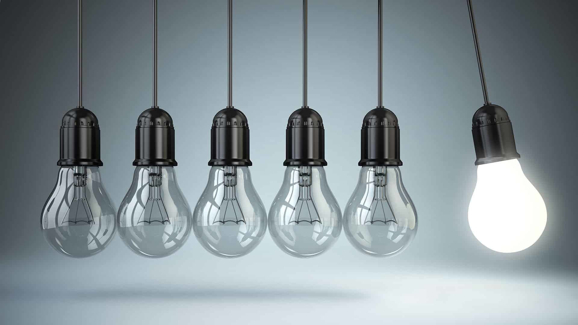 Row of hanging light bulbs with one illuminated bulb representing leadership, authority, and clear decision-making