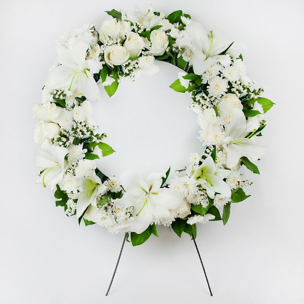 All white wreath for memorial service with lilies and roses