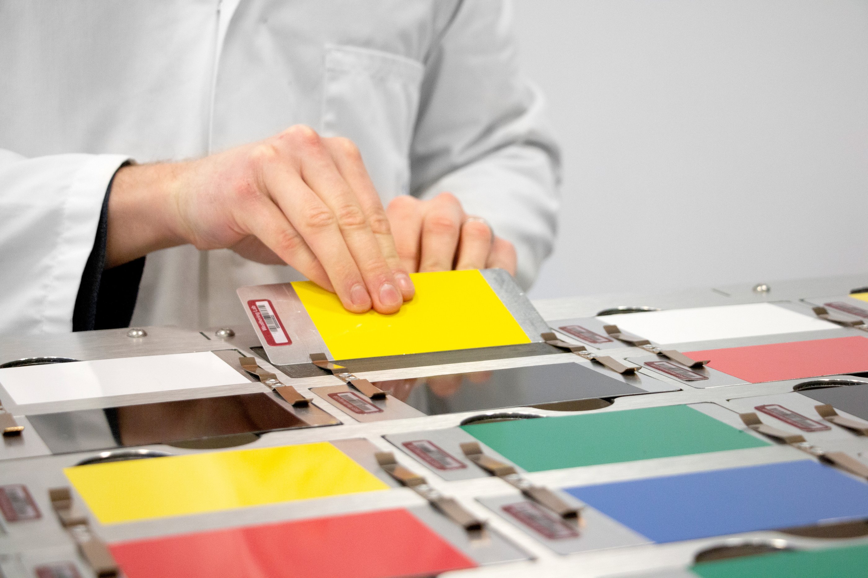 Barcoded colour cards being placed into a rack in a lab ready for analysis