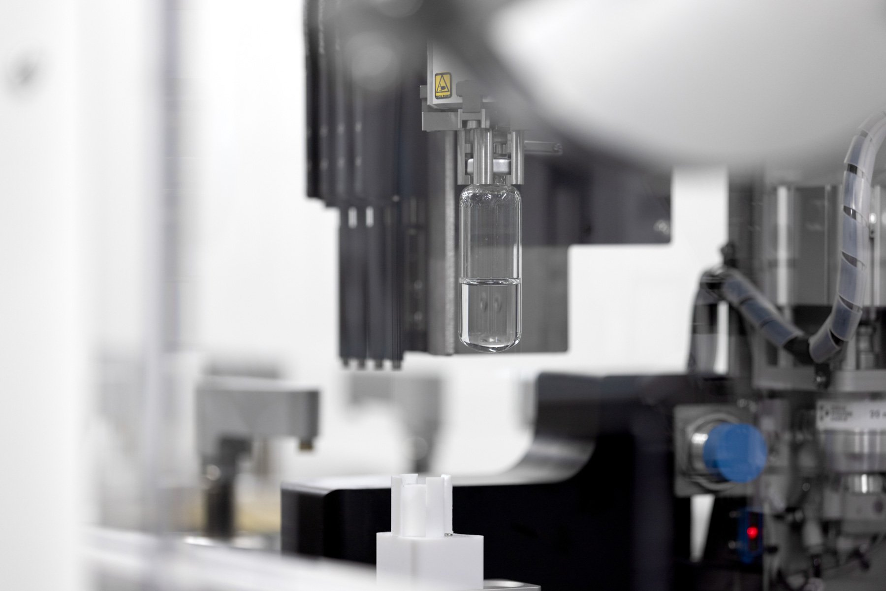 A vial being held by the robotic gripper