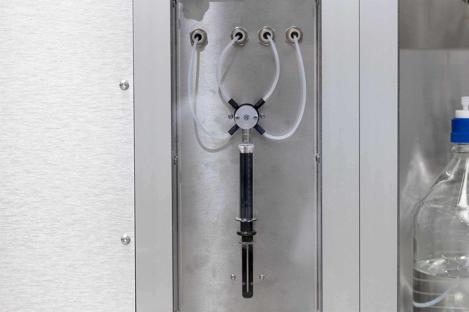 A Hamilton syringe with tubing integrated onto a metal robotic system