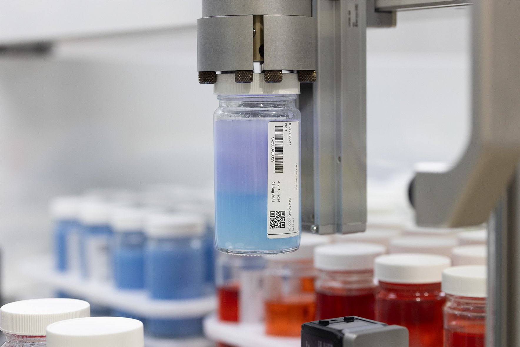 Pot of a purple-blue substance being held by a Labman 4 jaw gripper