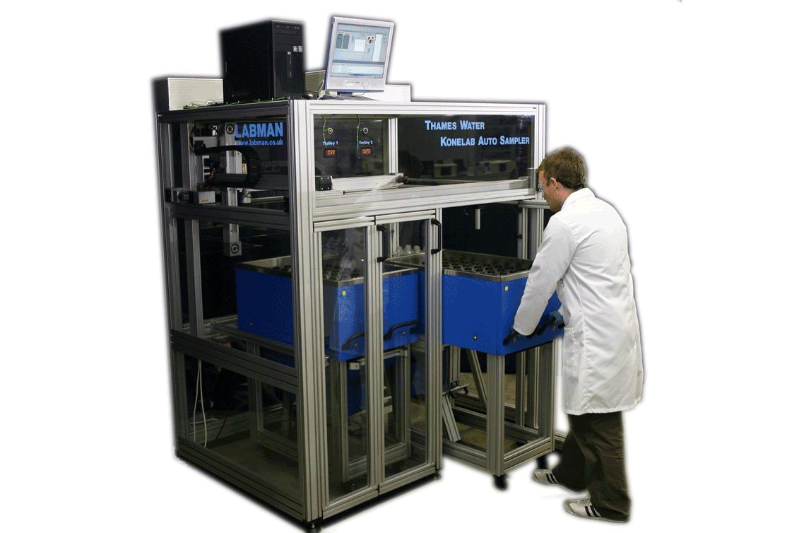 A labman custom robotic system with a man in a lab coat standing next to it 