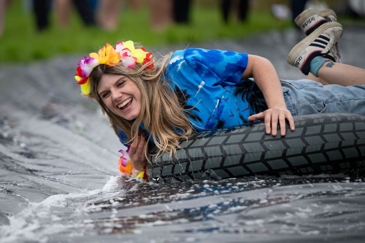 Labman team member laid on a rubber ring sliding on wet slip 'n slide