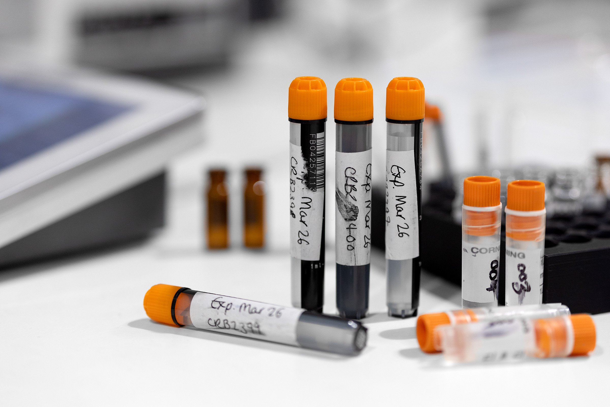 Plastic vials in a laboratory, labelled with smudged, handwritten and ripped labels