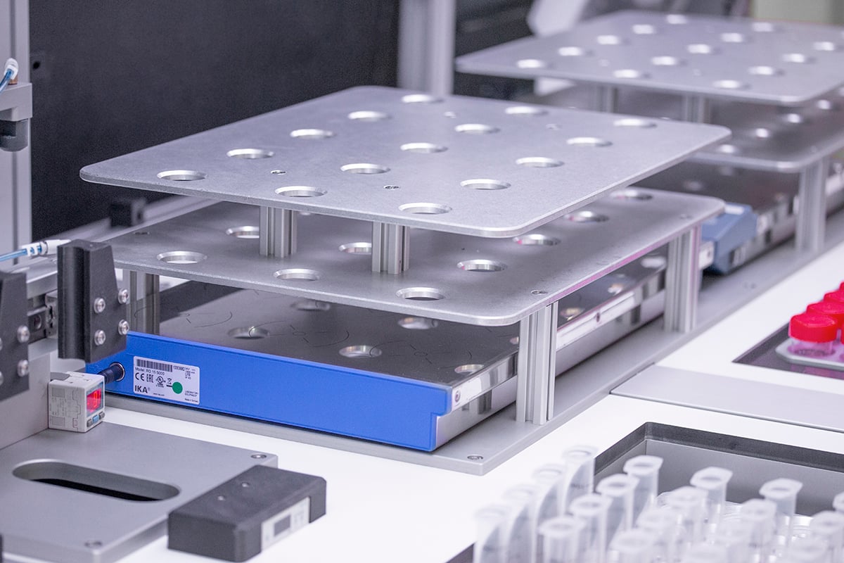 Close up of silver vial racks in a robotic system