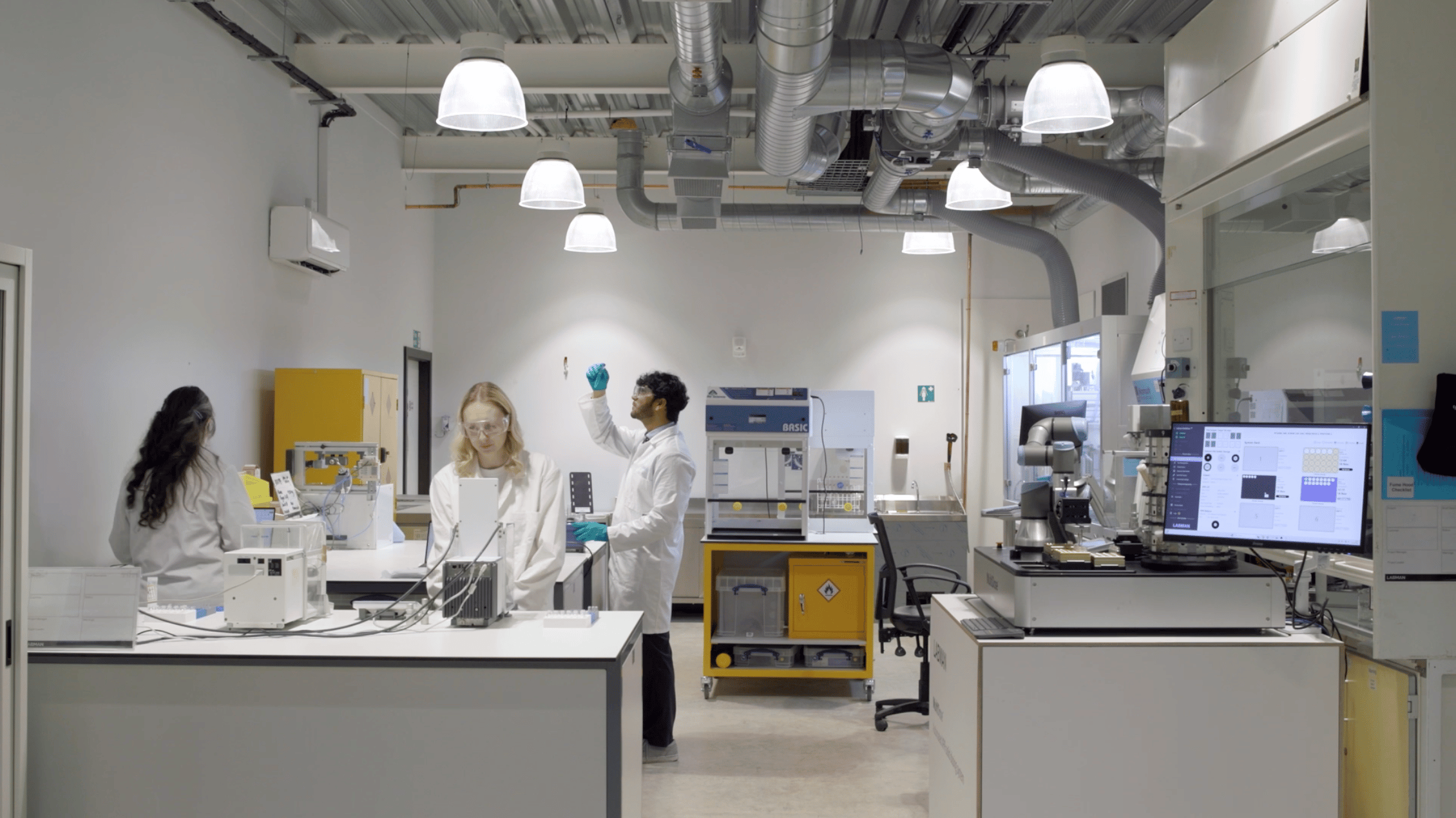 Three people working in a laboratory with lab equipment and instruments
