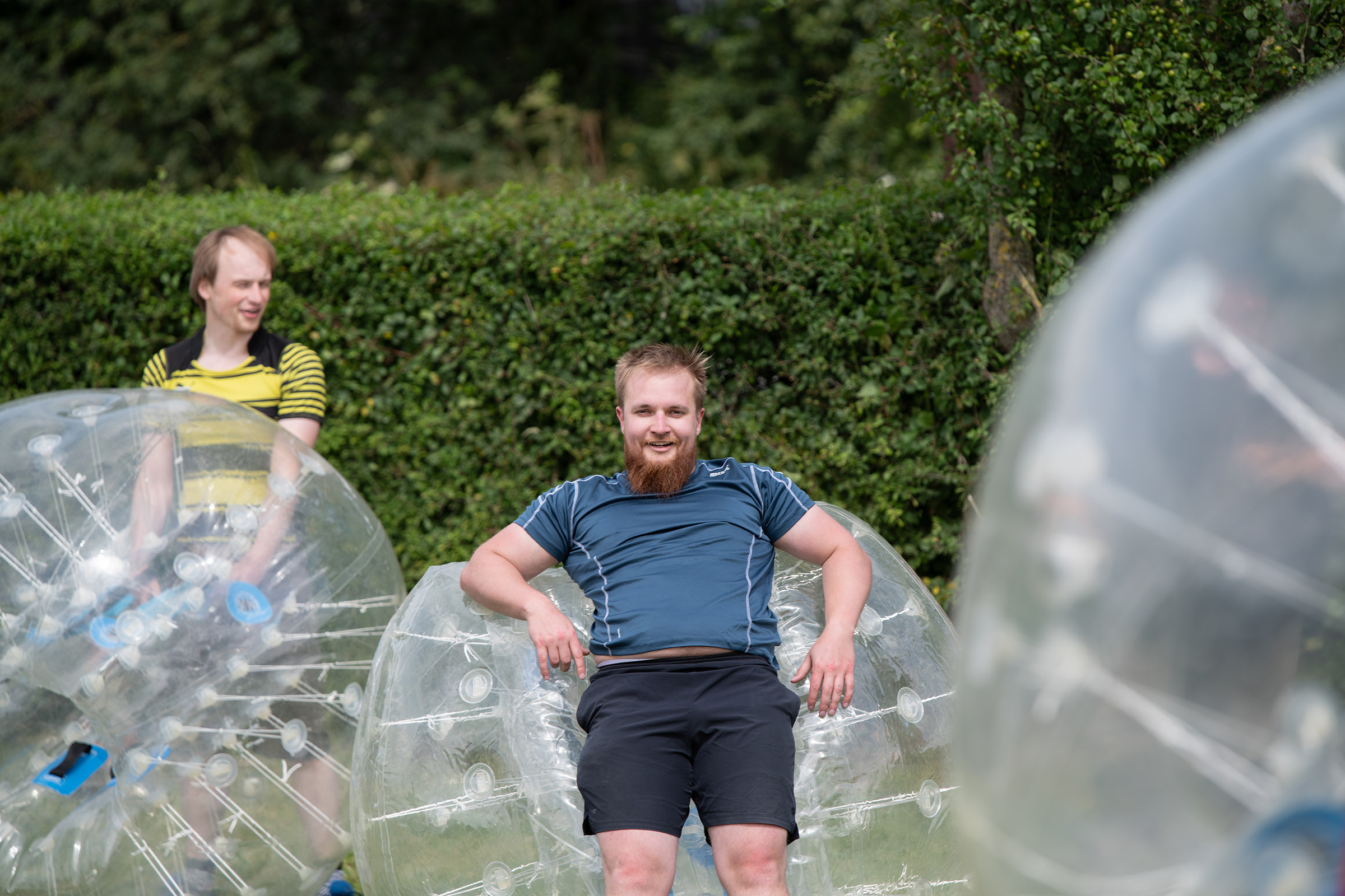 A young male resting on a giant inflatable ball