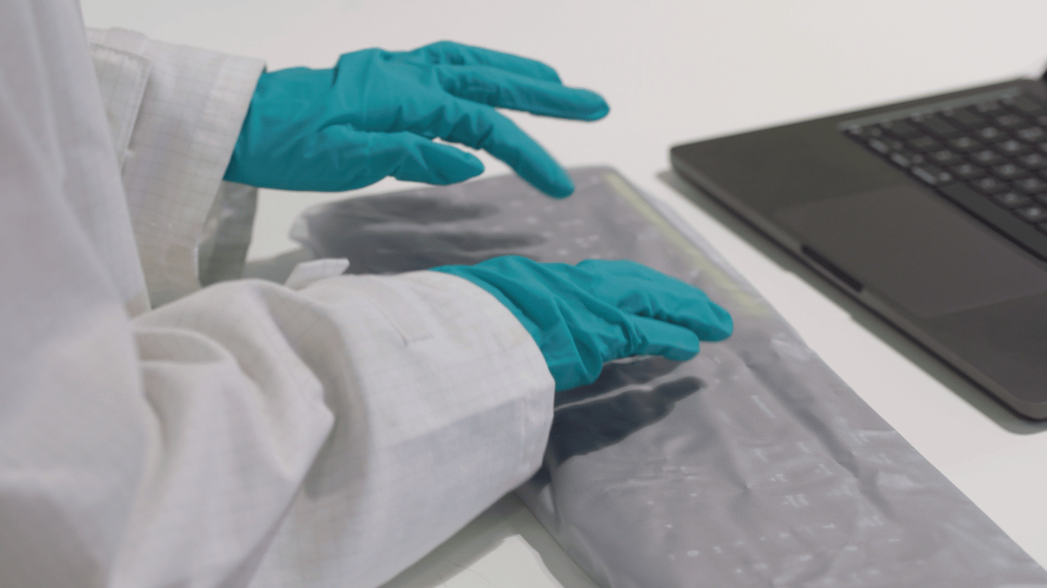 A close up somebody typing in a cleanroom laboratory environment