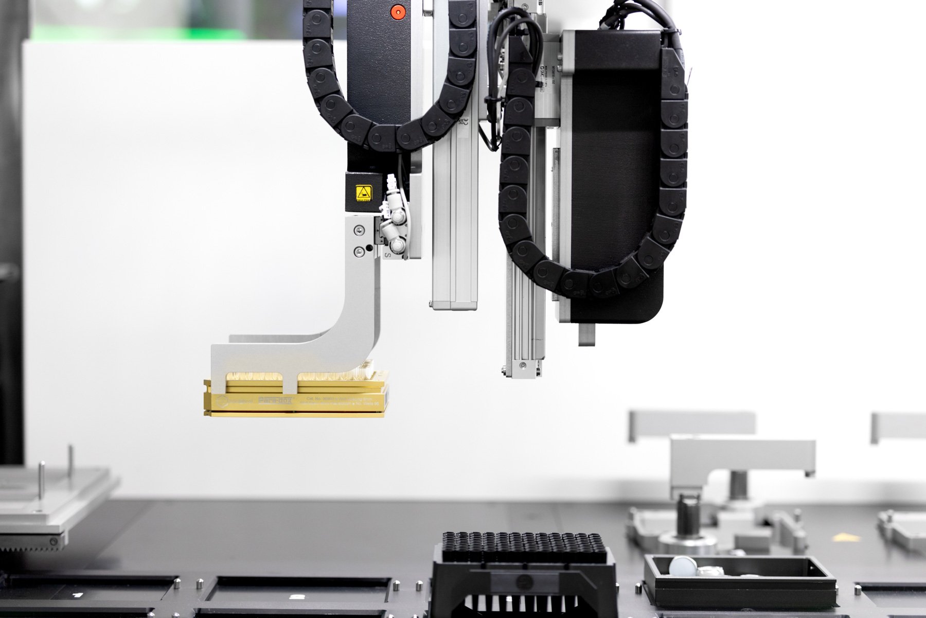 Robot arm seen from the side holding a vial rack