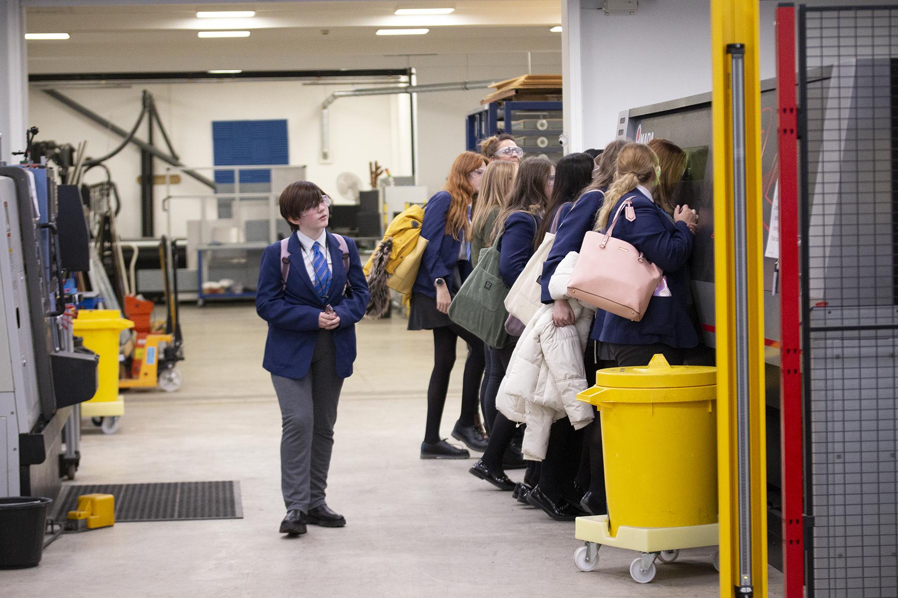 Female school students learning about machinery in Labman workshop