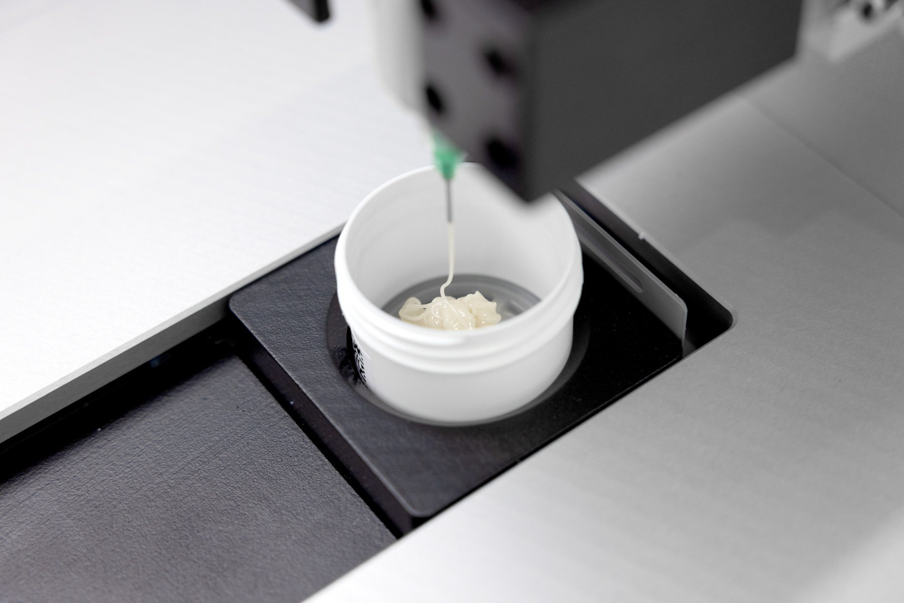 A formulation being dispensed from a syringe into a pot on an automated system