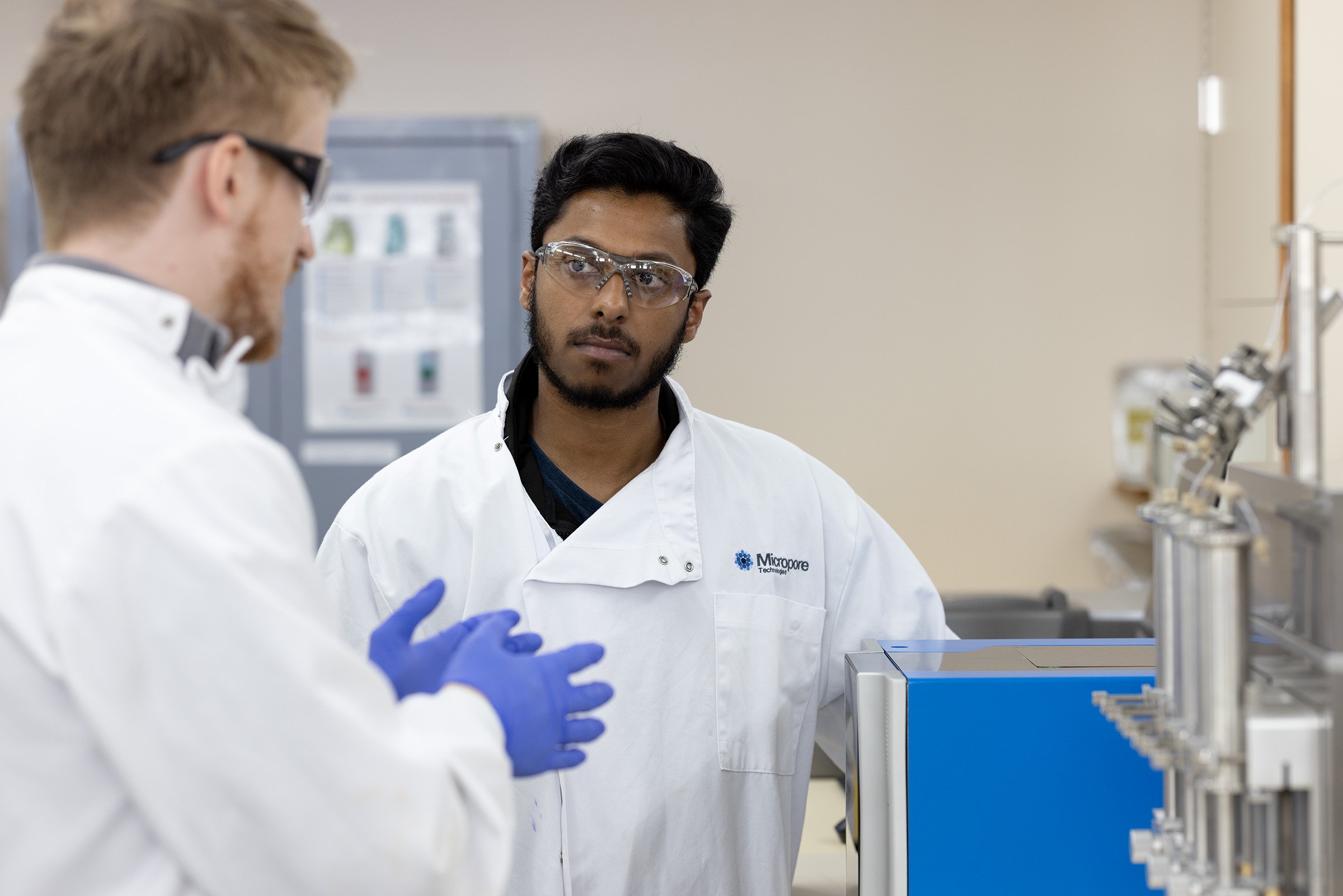 Labman engineer and Micropore technician talking, wearing lab coats