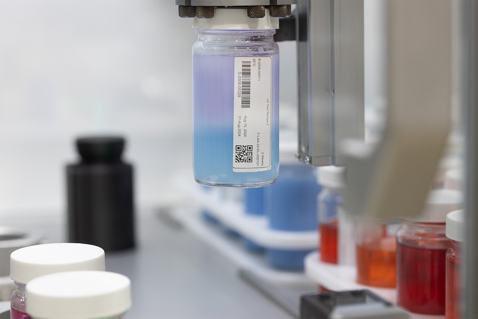 Pot of a purple-blue substance being held by a Labman 4 jaw gripper