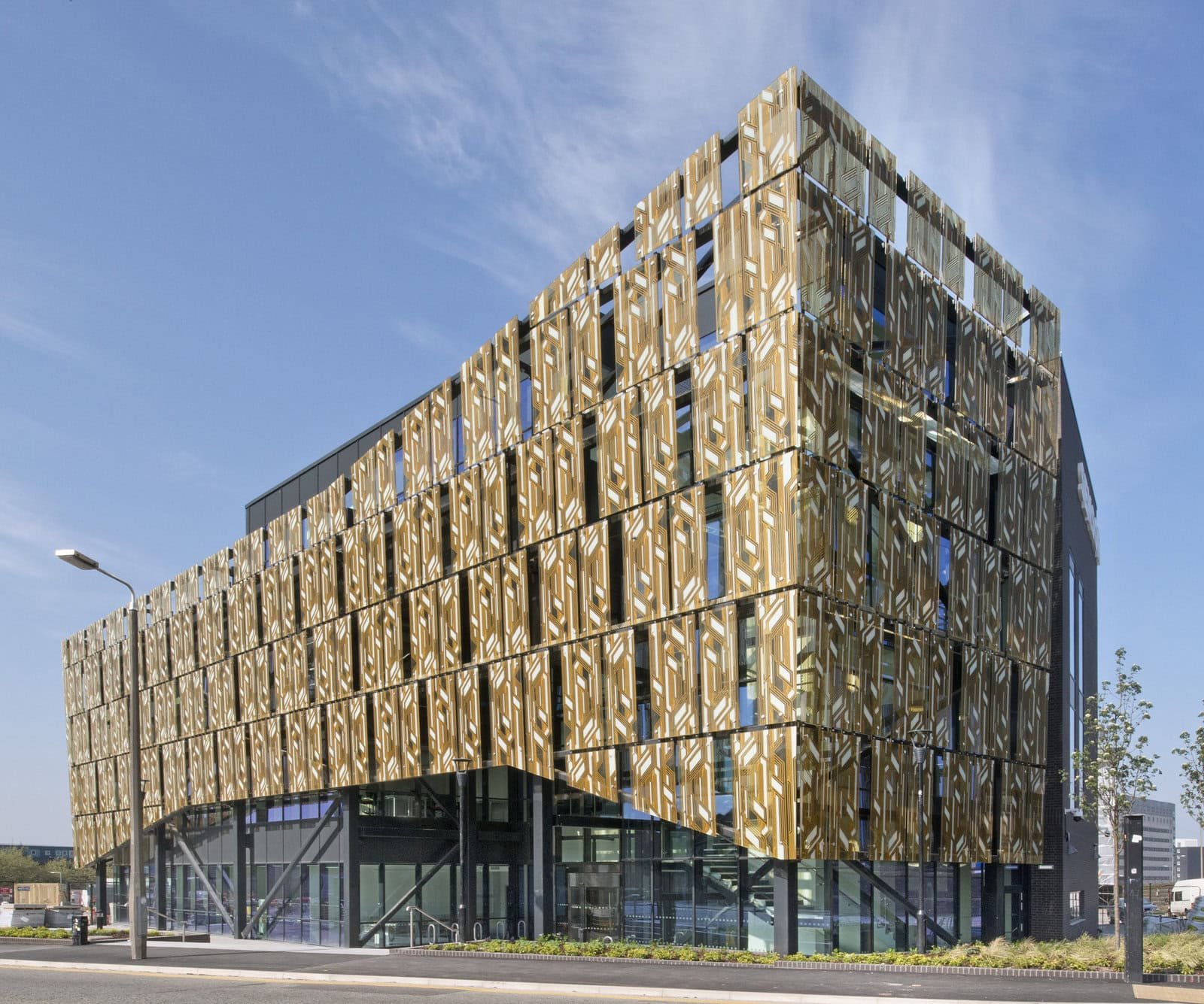 A large brown and grey building on a road with blue sky in the background