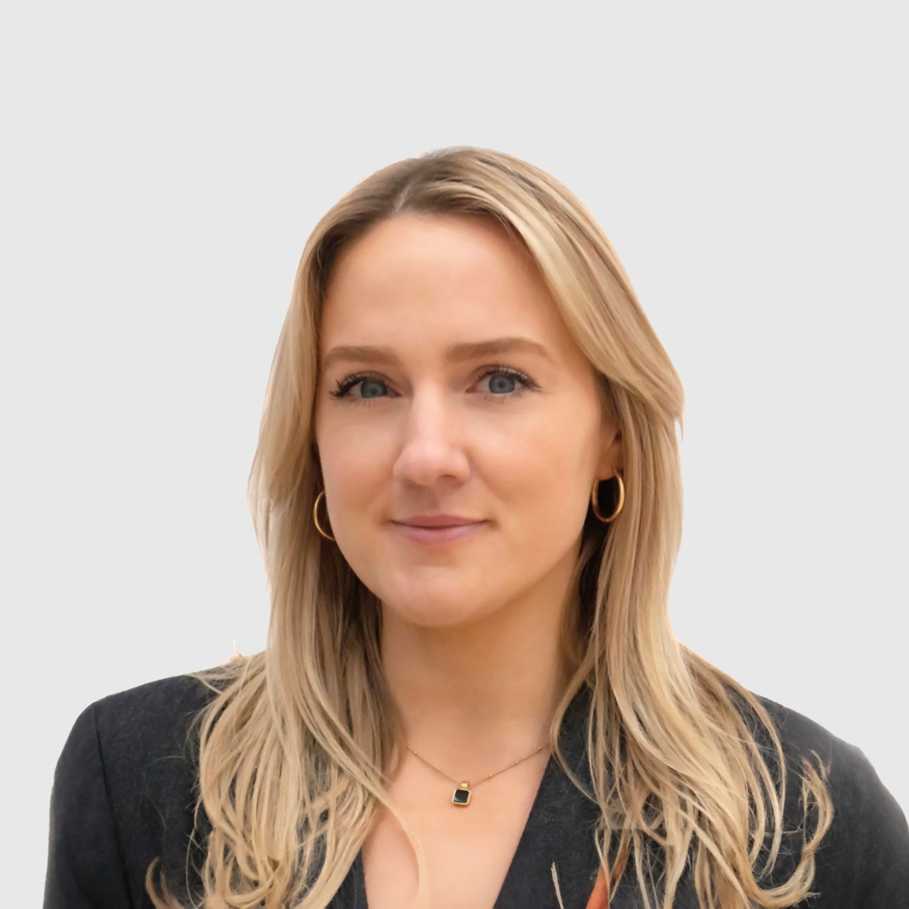 A headshot of a blonde woman smiling with a white background