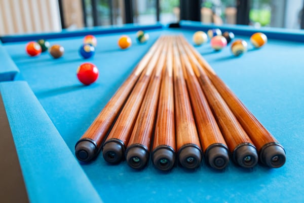 Close-up view of a blue pool table with billiard cues and balls, representing Agoura Hills Special Items Handling by OverEasyMovers.
