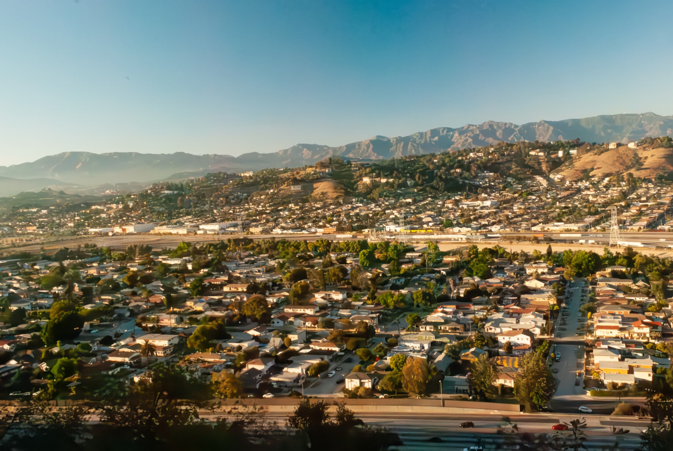Overhead view of Alhambra, California with residential homes and mountains, highlighting the benefits of moving to Alhambra with OverEasyMovers.