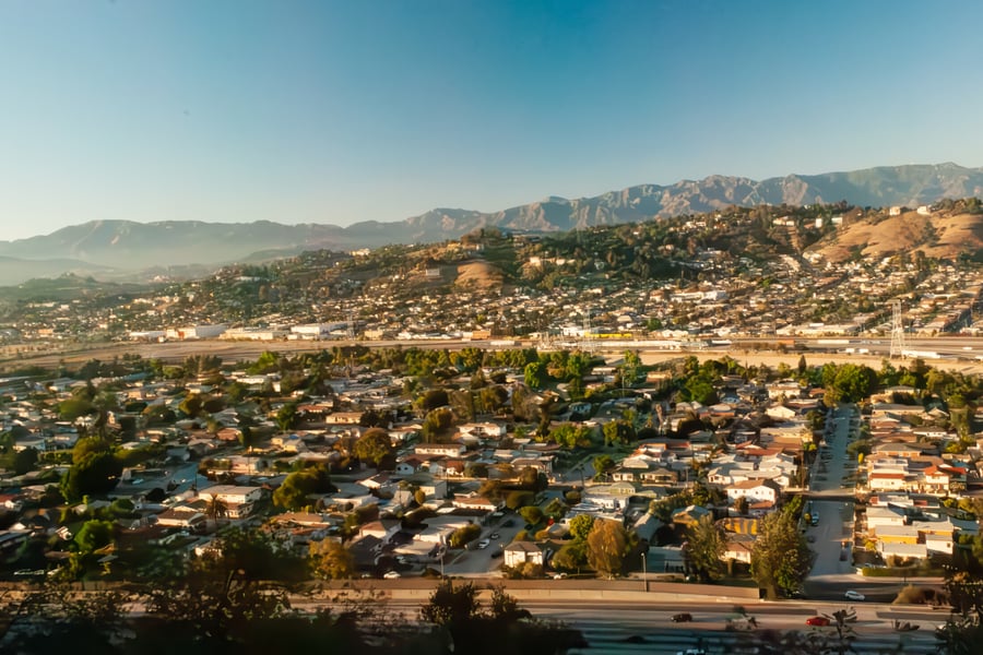 Overhead view of Alhambra, California with residential homes and mountains, highlighting the benefits of moving to Alhambra with OverEasyMovers.