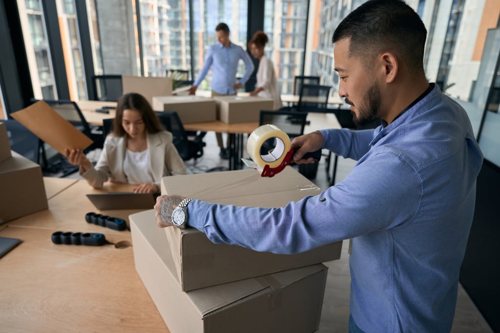 Business moving Anaheim with OverEasyMovers team packing office equipment.