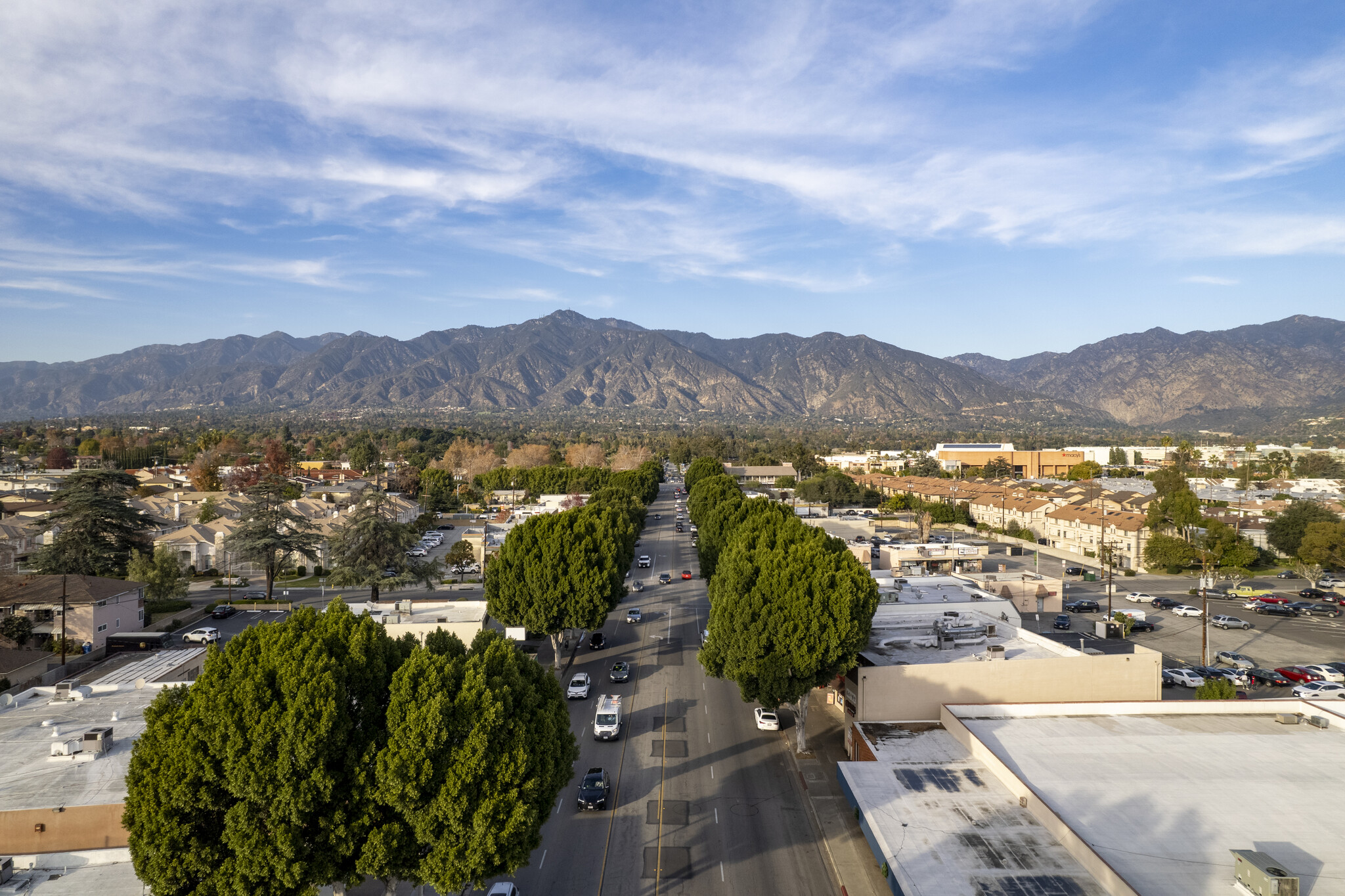 Packing Services 1 A scenic view of Arcadia, California, showcasing a tree-lined street with the San Gabriel Mountains in the background, perfect for local moving in Arcadia with OverEasyMovers.