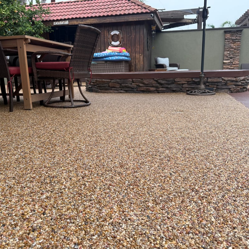 Outdoor patio with pebble epoxy stone carpet flooring by Stone Carpet Pros, featuring natural river pebbles and UV-stable epoxy for a durable, slip-resistant surface.